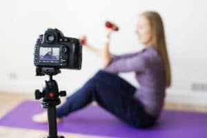 Female vlogger recording sports related broadcast at home