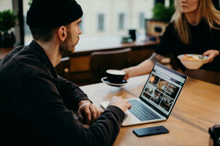 Man and a woman sitting at a table with a laptop