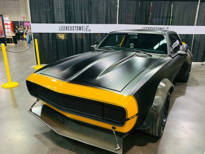 Yellow and black muscle car parked in a garage