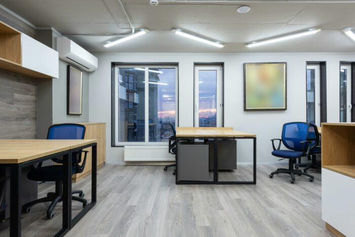 Room with a desk, chairs, and a large window