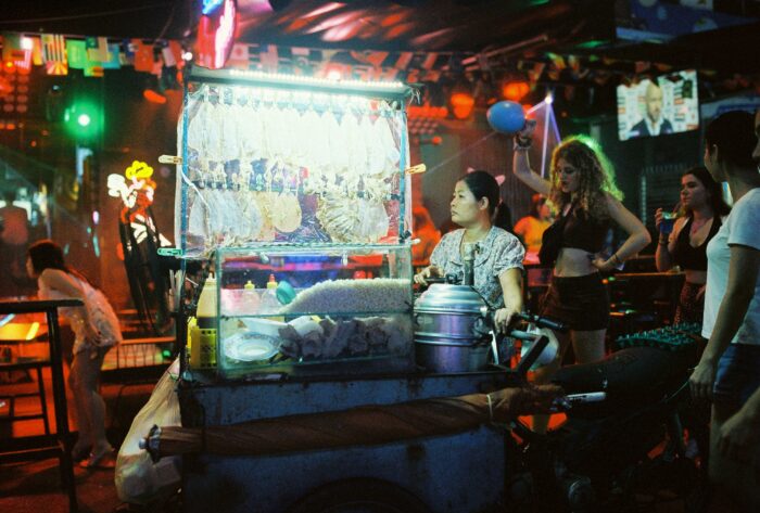 Group of people standing around a food cart