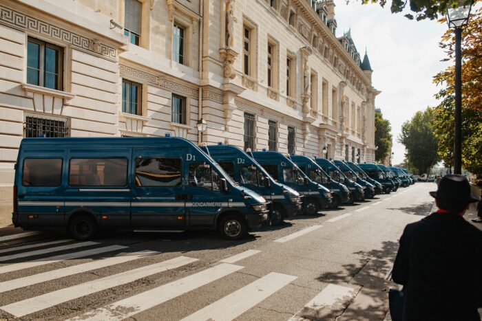 Row of blue vans parked on the side of a street