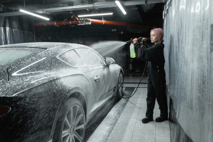 Man washing a car in a garage