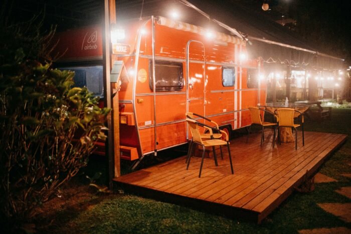 Orange food truck parked on a wooden deck
