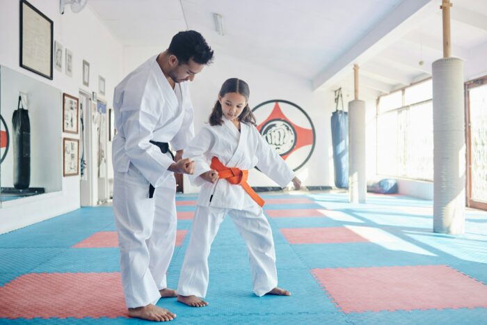Shot of a young man and cute little girl practicing karate in a studio