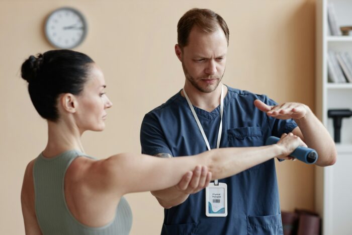 Woman training with dumbbells with therapist