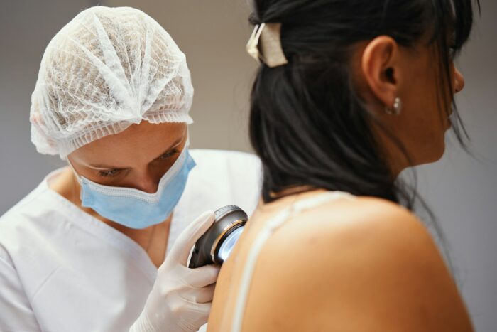 A dermatologist examines the skin.