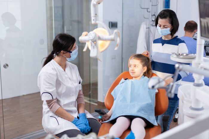 Dentist wearing face mask in the course kid examination