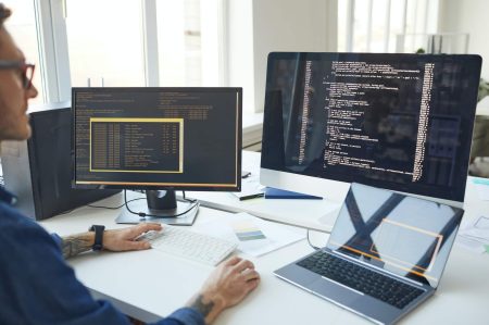 IT Programmer Writing Code on Computer Screen