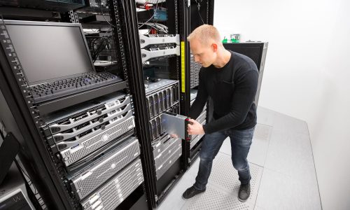 IT Technician Installing Blade Server In Chassis At Datacenter IT Technician Installing Blade Server In Chassis At Datacenter