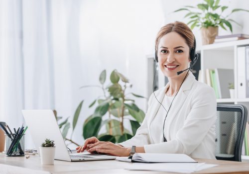 support operator working with headset and laptop in call center